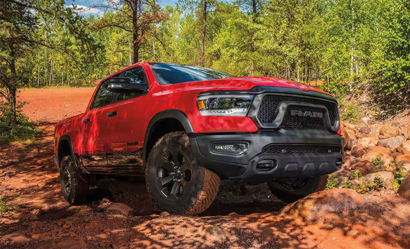 The 2023 Ram 1500 being driven off-road on a red rock trail.